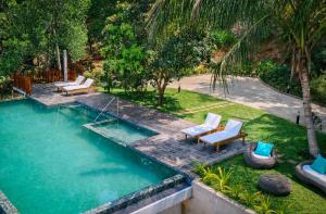 an empty swimming pool with lounge chairs in a yard at Kandy Neela Weralu in Haragama
