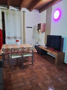 a room with a table and chairs and a television at Respiro di Lago - Pool Friend in Paratico