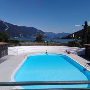 a large swimming pool with a view of the water at Respiro di Lago - Pool Friend in Paratico