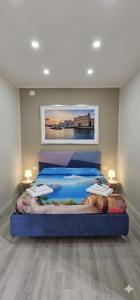 a bedroom with a large bed with a painting on the wall at Habibi Gerard in Torre del Greco