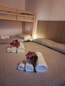 a hotel room with two beds with towels and flowers at Respiro di Lago - Pool Friend in Paratico +14 photos
