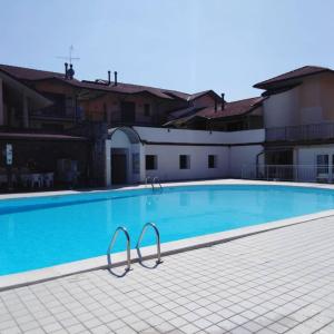 a large blue swimming pool with two metal bars around it at Respiro di Lago - Pool Friend in Paratico