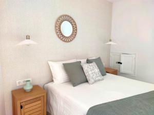a bedroom with a bed with a mirror on the wall at Luz de Belén in Jaén +1 photo