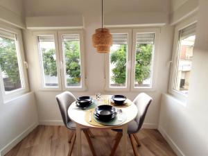 a dining room with a table and chairs and windows at Luz de Belén in Jaén