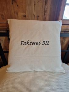 a white pillow with the word on it at Faktorei 312 in Eibau