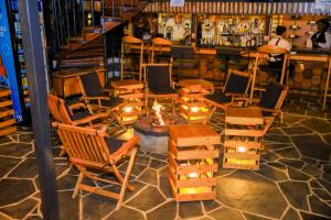 a bar with chairs and a fireplace in a room at Fortunas Resort Nkubu, Meru in Nkubu