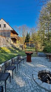 a group of benches and a table and a fire pit at Chalet Olešnice in Olešnice v Orlických horách
