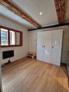 an empty room with a wooden floor and a television at Faktorei 312 in Eibau
