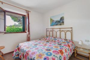 a bedroom with a bed and a window at Hause Sant'Ilario in Campo nell'Elba
