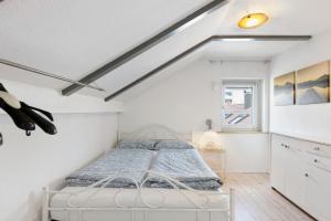 a white bedroom with a bed and a window at Fewo Kurt in Villingen-Schweninngen in Villingen-Schwenningen