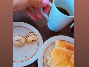 a table with two plates of food and a cup of coffee at Quartos Viracopos independente in Campinas +4 photos