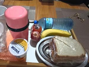 a tray of food with a plate of bread and fruit at Quartos Viracopos independente in Campinas