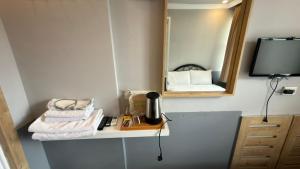 a bathroom with a mirror and towels on a shelf at YALI PANSİYON in Kaş