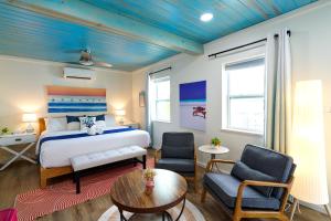 a bedroom with a bed and two chairs and a table at Casa Limonada Boutique Motel in Sarasota