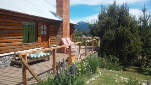 a wooden deck with two chairs on a cabin at Cabanas Peumahue in Villa Meliquina