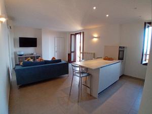 a kitchen and a living room with a blue couch at Maisonette Agata in Toscolano Maderno +13 photos