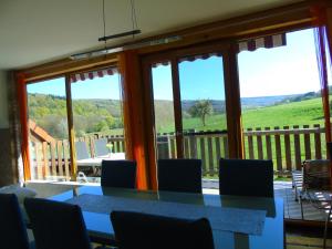 a dining room with a table and chairs and windows at Ferienwohnung Csilla in Unterweid