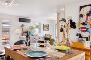 a dining room with a table with plates and wine glasses at Villa Bleu Azur - piscine, plages in Angles