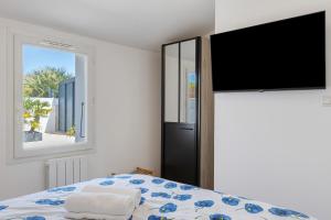 a bedroom with a bed and a flat screen tv at Villa Bleu Azur - piscine, plages in Angles +21 photos