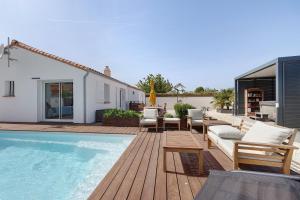 a backyard with a pool and chairs and a house at Villa Bleu Azur - piscine, plages in Angles