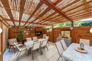 a patio with tables and chairs and a wooden ceiling at Charming LUCCA in Lucca