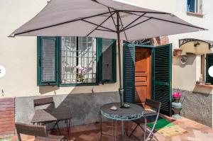 a table and chairs with an umbrella on a patio at Charming LUCCA in Lucca