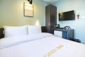 Postel nebo postele na pokoji v ubytování Grid Inn Hotel