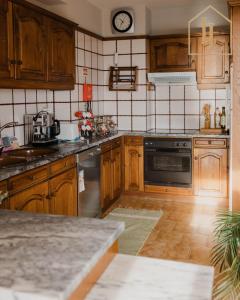 a kitchen with wooden cabinets and a clock on the wall at Casa da Amorosa com Vista Mar by Lethes Legacy in Abelheira