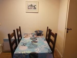 a dining room table with a blue table cloth and chairs at Studio in Argentat +2 photos