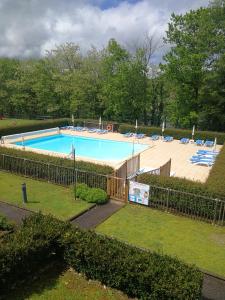a large swimming pool with chairs in a yard at Studio in Argentat