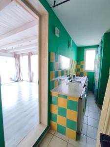a kitchen with green and colorful tiles on the wall at Terrazza Lumière in Alezio