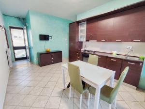 a kitchen with a white table and chairs at Terrazza Lumière in Alezio