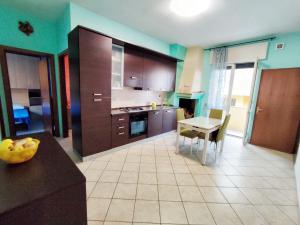 a kitchen with a table and a dining room at Terrazza Lumière in Alezio