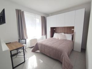 ein Schlafzimmer mit einem Bett, einem Tisch und einem Fenster in der Unterkunft BnB Ranco in Ranco