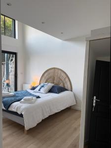 a white bedroom with a large bed and a window at Le rivage 44 in Bénouville