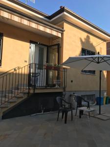 a patio with an umbrella and a table and chairs at R&B MiDora Montale in Montale