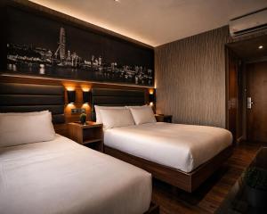 a hotel room with two beds and a painting on the wall at London Court Hotel in London