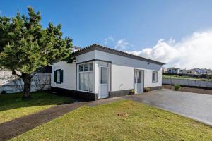 a small white house with a large driveway at Carmen's Place in Ponta Garça