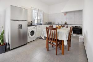 a kitchen with a table and a refrigerator at Carmen's Place in Ponta Garça