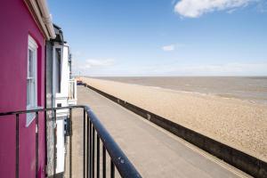 a view of the beach from the balcony of a building at Magenta - A stunning Seafront house with lovely and uninterrupted Beach Views - Aldeburgh Coastal Cottages in Aldeburgh