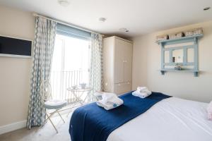 a bedroom with a large bed with towels on it at Magenta - A stunning Seafront house with lovely and uninterrupted Beach Views - Aldeburgh Coastal Cottages in Aldeburgh