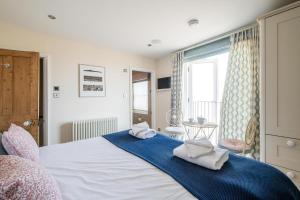 a bedroom with a bed with towels on it at Magenta - A stunning Seafront house with lovely and uninterrupted Beach Views - Aldeburgh Coastal Cottages in Aldeburgh +32 photos