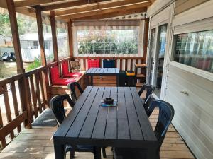 a porch with a wooden table and chairs on it at Bonne anse plage in Les Mathes