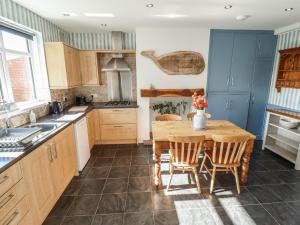 a kitchen with a wooden table and chairs at Sorrento in Mablethorpe