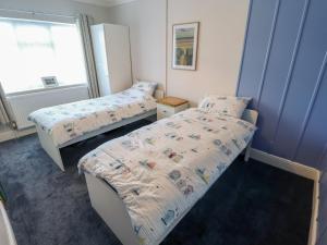 a bedroom with two beds and a window at Sorrento in Mablethorpe