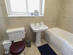 a bathroom with a toilet and a sink and a tub at Sorrento in Mablethorpe +13 photos