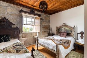 a bedroom with two beds and a window at Villa Miranda Heritage House in Creixomil +45 photos