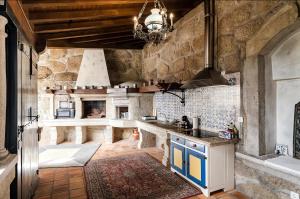 a large kitchen with a large stone wall at Villa Miranda Heritage House in Creixomil