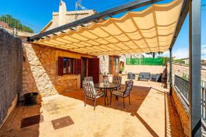 a patio with a table and chairs under awning at Villa Sa Costa - Families or Couples Only in Calvià
