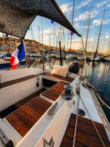 a boat with a wooden deck in the water at Nuit Insolite à bord d'un Voilier Sète Vieux Port in Sète